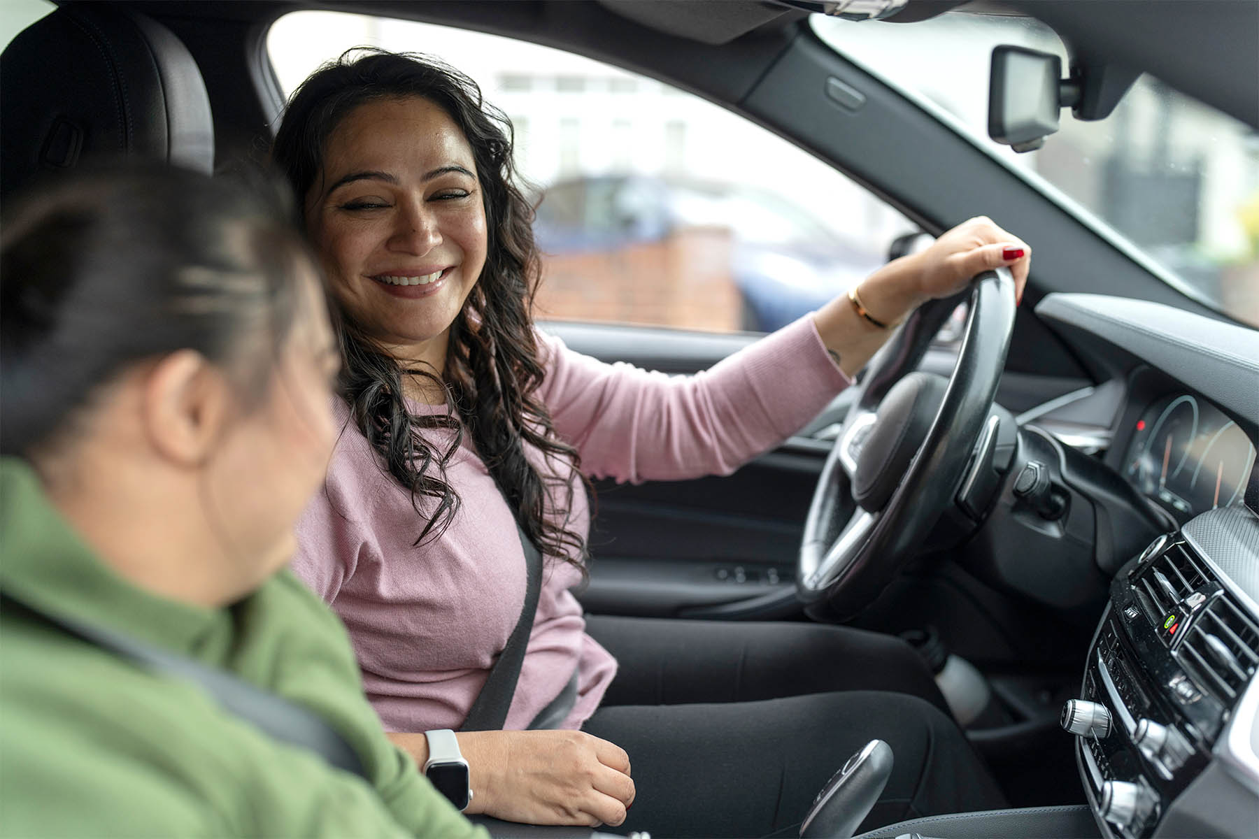 Woman driving young girl smiling